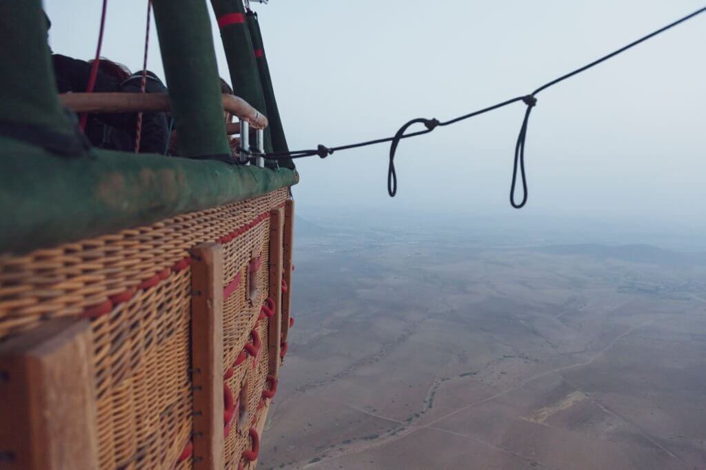 side-view-of-the-basket-of-a-hot-air-balloon-flying-Hot-Air-Balloon-Flight-Marrakech-tour-by-nomad-excursion-travel-agency
